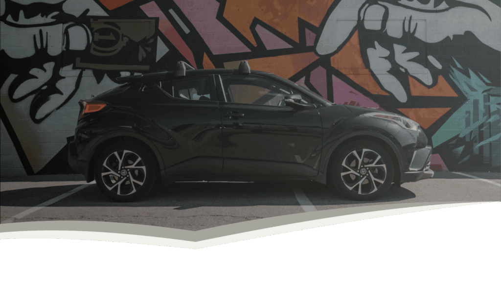 StreetSafe Driving School black car parked in front of graffiti wall