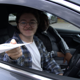 StreetSafe Driving School instructor watching as happy student is handed his pass certificate