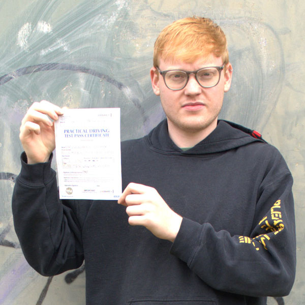 student holding practical driving test pass certificate